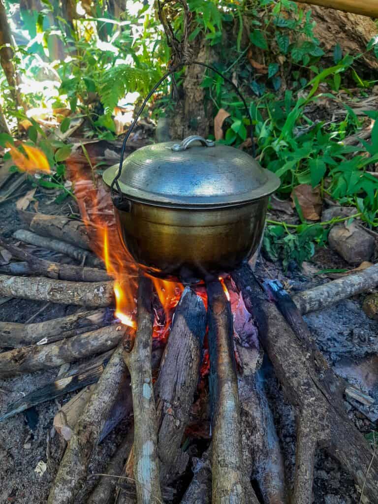 Traditional Grenadian oil down stew cooking in an iron pot.
